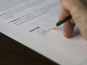 Person Signing on Paper